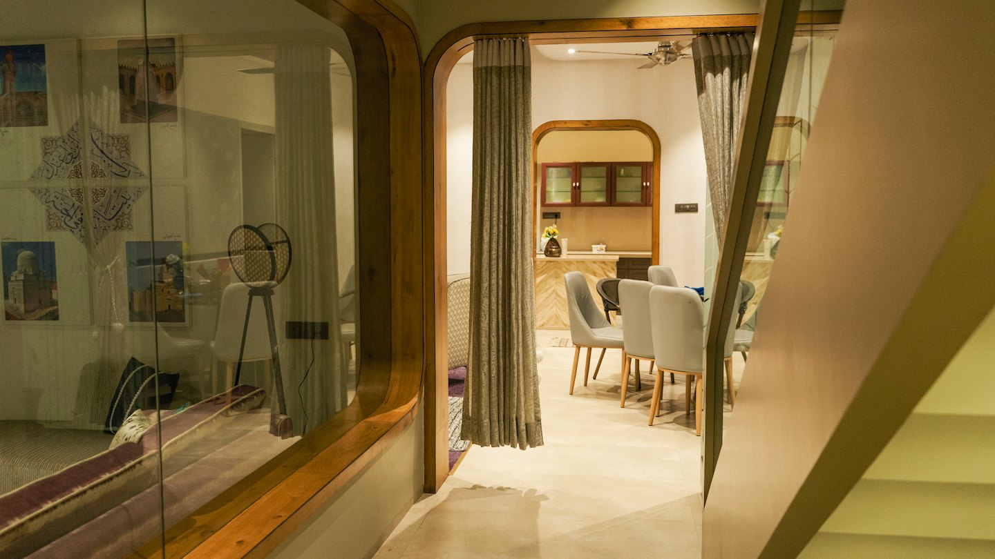 Intérieur de maison moderne décloisonnée vu à travers une arche en bois.