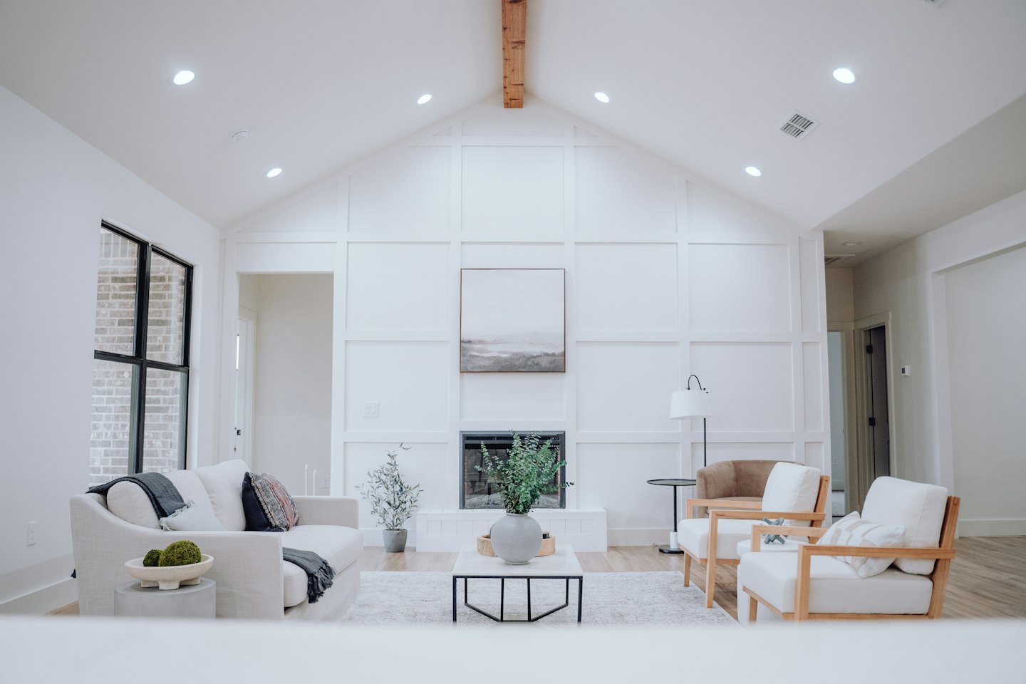 Salon moderne avec plafond cathédrale et poutre en bois.